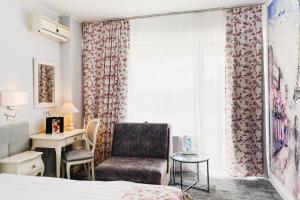 奥拉迪亚大陆论坛奥拉迪亚酒店的卧室配有床、椅子和窗户。