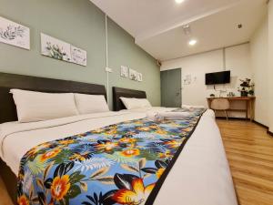 哥打京那巴鲁Treeline Urban Inn的一间卧室配有一张大床和色彩缤纷的毯子