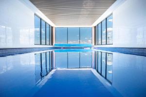 堪培拉Lux 2 Bed 2 Bath Apartment in the Heart of Dickson, Canberra的一座带窗户的建筑里,有一个蓝色的游泳池