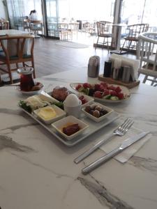 库古库俞Denizkizi butik otel的餐桌上放有盘子的桌子