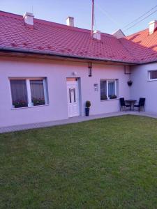 Kráľovský ChlmecVilla Monica的院子内带桌椅的白色房屋