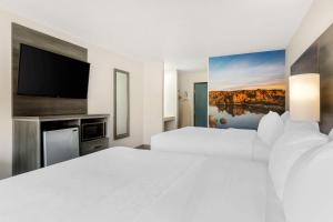 普雷斯科特山谷Clarion Pointe Prescott Valley的酒店客房设有两张床和一台平面电视。