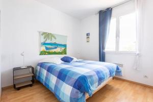 居让梅斯特拉Bassin Arcachon, Mais. 3 étoiles, spa, 500 m plage的卧室配有蓝色和白色的床和窗户。
