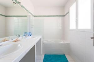 居让梅斯特拉Bassin Arcachon, Mais. 3 étoiles, spa, 500 m plage的白色的浴室设有浴缸、水槽和浴缸。