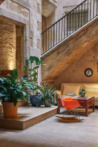 巴塞罗那Hotel Neri – Relais & Chateaux的一间设有椅子和桌子的房间,并种植了植物