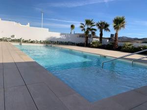 圣何塞Casa del Mar的一座棕榈树大型游泳池和一座建筑