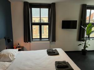 弗拉讷克道伦咖啡馆酒店的一间卧室配有一张床,上面有两条毛巾