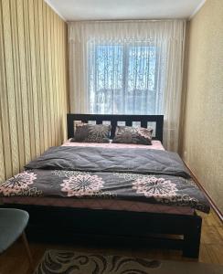 罗夫诺4-км в центрі міста的一间卧室设有一张大床和窗户