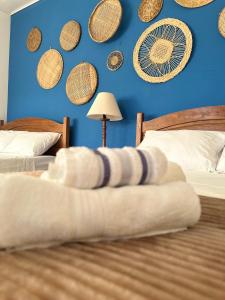 帕拉蒂Pousada Mawe的一间卧室设有两张床和蓝色的墙壁