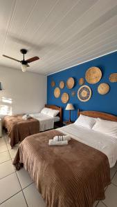 帕拉蒂Pousada Mawe的一间卧室设有两张床和蓝色的墙壁