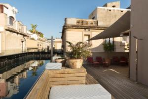巴塞罗那Hotel Neri – Relais & Chateaux的一个带椅子和水池的庭院