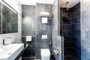 阿默斯福特Bastion Hotel Amersfoort的一间带水槽、卫生间和镜子的浴室