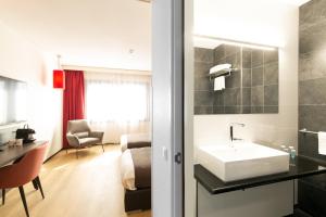 阿默斯福特Bastion Hotel Amersfoort的一间带水槽的酒店浴室和一间客房