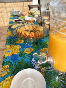 帕拉蒂Pousada Mawe的一张桌子,上面放着一盘食物和一杯橙汁
