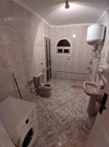 Dawwār Abū MaḩrūsSpacious 3 bedroom apartment with a sea view.的一间带洗衣机和卫生间的浴室