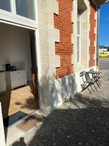 滨海苏拉克Appartement familial centre et plage的通往砖砌建筑的门,配有两把椅子