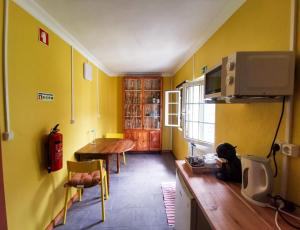 圣克鲁斯达格拉西奥萨Casa da Emilie的厨房配有桌子和黄色的墙壁