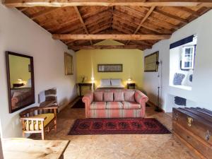 圣克鲁斯达格拉西奥萨Casa da Emilie的一间配有沙发的卧室和一张位于客房内的床