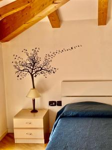 阿科Casa Gianna的卧室墙上有一棵树,墙上有鸟儿