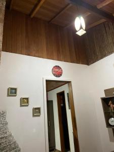 蒙特韦尔迪Apartamento Refúgio MV的墙上有一扇门和一个钟的房间