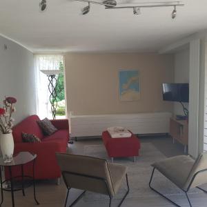 埃尔默洛Bungalow Veluwemeer的客厅配有红色沙发和电视