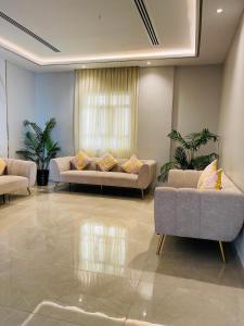 锡卜胡辛阿尔卡里公寓酒店的客厅设有两张沙发和一个窗户