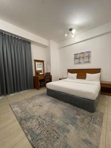 锡卜胡辛阿尔卡里公寓酒店的一间卧室设有一张大床和一个窗户。