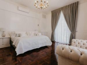 开普敦Akamah Estate的白色卧室配有一张床和一个吊灯