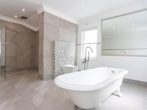 开普敦Akamah Estate的白色的浴室设有浴缸和淋浴。