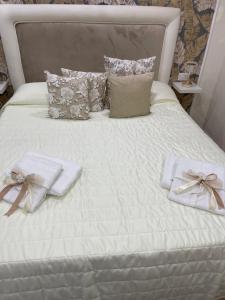 那不勒斯La Dimora Dei Sogni的一张带2条毛巾和枕头的白色床