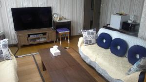 札幌旅の宿ていね的客厅配有两张沙发和一台电视机