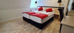 奥尔堡Prinsen Hotel的一间卧室配有一张带红色枕头的床