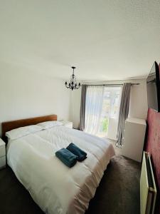 曼彻斯特Barnstaple Drive House的卧室配有白色床和2条蓝色毛巾
