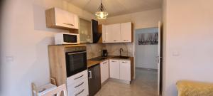 萨利Apartments Orlić的小厨房配有白色橱柜和微波炉