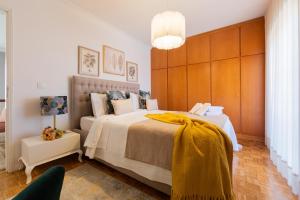 布拉加Maria Home Reall's的一间卧室配有一张大床,床上有黄色的毯子