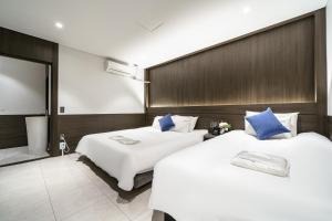 釜山WABA Classic Gwanganri的两张位于酒店客房的床,配有蓝色枕头
