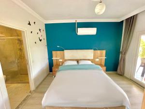 达拉曼Airport Guest House的一间卧室设有一张床和蓝色的墙壁