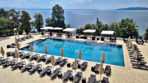 奥帕提亚Hotel Ambasador - Liburnia的一个带躺椅和遮阳伞的大型游泳池
