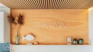 阿坎提拉德洛斯基ZAMA Apartment的木墙上标有zamana标志