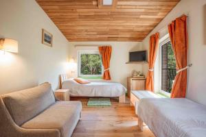 帕兰加Gintarautojai的一间卧室设有两张床、一张沙发和一个窗口