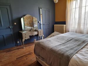 Saint-Amand-JartoudeixBon Chez Nous的一间卧室配有床、梳妆台和镜子