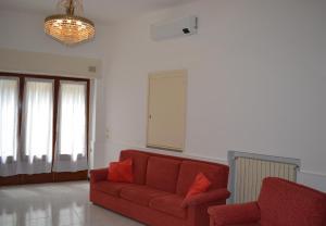 莱萨L'Antico Borgo的客厅配有红色沙发和吊灯