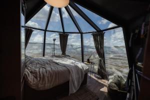 赫尔Yggdrasil Igloo Skåne的一张位于带大窗户的房间内的床铺