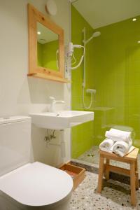 帕兰加Gintarautojai的浴室设有水槽、卫生间和绿色瓷砖。