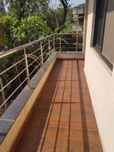 罗纳瓦拉Hotel Trisha Residency的一个带木制走道的房屋的阳台