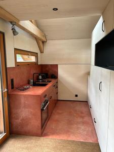 圣若里奥Le Cabanon的一间带水槽的小厨房和一台电视