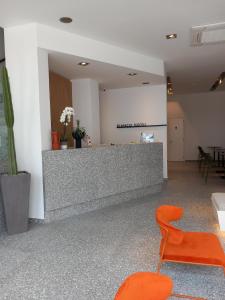 LakkíonBianco Hotel的办公室设有前台和橙色椅子