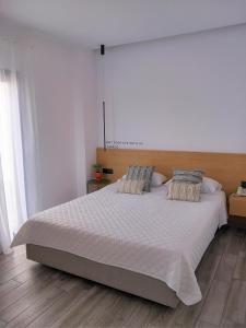 LakkíonBianco Hotel的卧室配有一张带两个枕头的大白色床