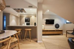 马德里U-Sense Madrid Santa Ana的厨房以及带桌椅的起居室。