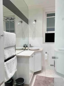 悉尼Stylish apartment in the heart of Potts Point的白色的浴室设有水槽和镜子